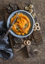 Healthy vegetarian snack - pumpkin hummus on a wooden cutting board