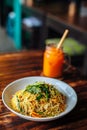 Healthy Vegetarian vegan menu Delicious Singapore style Stir fried rice noodles with carrot orange smoothies on wooden table in
