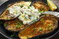 Healthy vegeterain Oven baked aubergines, Eggplant with cottage cheese dip, parsley and lemon wedge.