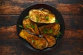 Healthy vegeterain Oven baked aubergines, Eggplant with parsley and herbs in a black plate Royalty Free Stock Photo