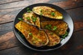 Healthy vegeterain Oven baked aubergines, Eggplant with parsley and herbs in a black plate Royalty Free Stock Photo