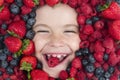 Healthy vitamins fruits. Mix of berries. Kids face with fresh berries fruits. Assorted mix of berries strawberry