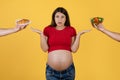 Healthy Vs Unhealthy. Doubtful Pregnant Woman Choosing Between Salad And Croissant Royalty Free Stock Photo