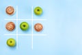 Healthy vs unhealthy food, green apples vs cinnamon buns in tic tac toe or noughts and crosses game, horizontal, top view, copy Royalty Free Stock Photo