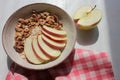 Healthy Walnut Red Apple Oatmeal in vintage bowl on white wooden table background. Natural lighting. Beautiful openwork shadow fro Royalty Free Stock Photo