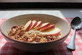 Healthy Walnut Red Apple Oatmeal in vintage bowl on white wooden table background. Natural lighting. Beautiful openwork shadow fro Royalty Free Stock Photo