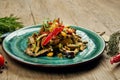 Healthy warm salad with grilled beef and vegetables on blue plate. Composition with salad and spices on a wooden background