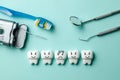 Healthy white teeth are smiling and tooth with caries is sad on green mint background. Toothbrush floss and dentist tools mirror, Royalty Free Stock Photo