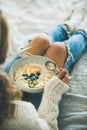 Woman in jeans and sweater eating healthy vegan breakfast Royalty Free Stock Photo