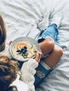 Woman in shabby jeans and sweater eating vegan breakfast Royalty Free Stock Photo