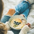 Woman in jeans and sweater eating vegan breakfast, square crop Royalty Free Stock Photo