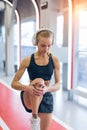 Healthy woman doing warmup exercise. Fit woman standing on red running track