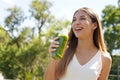 Healthy woman drinking green smoothie detox juice with kiwi mint kale outdoors Royalty Free Stock Photo