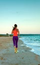 Healthy woman jogger on seashore in evening running Royalty Free Stock Photo