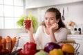 Healthy woman in a kitchen with fruits and vegetables and juice