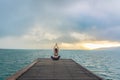 Healthy woman lifestyle balanced practicing meditate and energy yoga on the wood bridge in morning the beach. Royalty Free Stock Photo