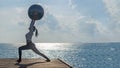 Healthy woman lifestyle balanced practicing meditate and zen energy yoga ball outdoors on the bridge in morning the sea nature. Royalty Free Stock Photo