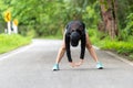 Healthy woman warming down stretching her legs and looking away in the road outdoor. Asian runner woman workout