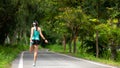 Healthy woman warming up before jogging run and relax stretching her arms and looking away in the road outdoor. Royalty Free Stock Photo