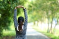 Healthy woman warming up stretching her arms. Asian runner woman workout before fitness and jogging session on the road nature par Royalty Free Stock Photo