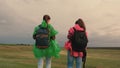 Healthy women tourists travel with backpacks in colorful raincoats. Slow motion. teamwork of travelers. Free girls