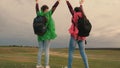 Healthy women tourists travel with backpacks in colorful raincoats. Slow motion. teamwork of travelers. Free girls