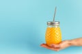 Healthy yellow smoothie jar with metal drinking straw on blue background. Zero waste, copy space Royalty Free Stock Photo