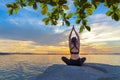 Healthy yoga woman lifestyle exercising vital meditate and energy yoga on the rock near the seashore, sunset Royalty Free Stock Photo