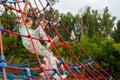 Healthy young active elementary school age girls, children climbing up high on playground equipment, ropes, exercise, leisure Royalty Free Stock Photo