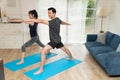 Healthy young Asian couple attractive couple practicing yoga exercises in an online class on quarantine at home. Concept of