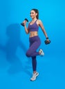 Healthy young asian fitness woman doing exercises with dumbbells isolated over blue background Royalty Free Stock Photo