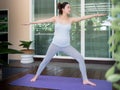 Healthy young Asian pregnant woman doing prenatal yoga on terrace at home.