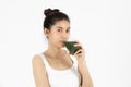 Healthy young Asian woman drinking green detox vegetable smoothie over white isolated background. Vegetarian drink juice, Healthy Royalty Free Stock Photo