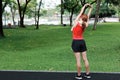 Healthy young Asian woman stretching her hands before run in park in morning. Workout and exercise concept Royalty Free Stock Photo