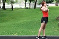 Healthy young Asian woman stretching her hands before run in park in morning. Workout and exercise concept Royalty Free Stock Photo