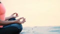 Healthy, young beautiful woman meditating, practicing yoga on the beach, by the sea, at sunrise, Relaxes muscles, mind Royalty Free Stock Photo