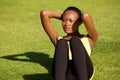 Healthy young black woman doing sit ups outdoors on grass Royalty Free Stock Photo