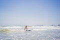 Healthy young boy learning to surf in the sea or ocean Royalty Free Stock Photo