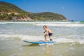 Healthy young boy learning to surf in the sea or ocean Royalty Free Stock Photo