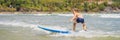 Healthy young boy learning to surf in the sea or ocean BANNER, LONG FORMAT Royalty Free Stock Photo