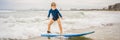 Healthy young boy learning to surf in the sea or ocean BANNER, LONG FORMAT Royalty Free Stock Photo