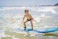 Healthy young boy learning to surf in the sea or ocean Royalty Free Stock Photo