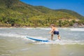 Healthy young boy learning to surf in the sea or ocean Royalty Free Stock Photo