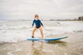 Healthy young boy learning to surf in the sea or ocean Royalty Free Stock Photo