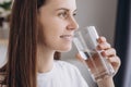 Healthy young female holding glass drinking fresh transparent pure filtered mineral water. Smiling pretty woman hydrating thirst Royalty Free Stock Photo