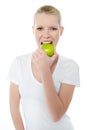 Healthy young girl eating nutritious green apple Royalty Free Stock Photo