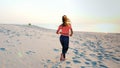 Healthy, young sports beautiful woman runs along the sand, on the beach, in summer, towards the sun, at the sunrise. Royalty Free Stock Photo