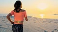 Healthy, young sports beautiful woman runs along the sand, on the beach, in summer, towards the sun, at the sunrise. Royalty Free Stock Photo