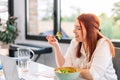 Healthy young woman eating salad while working Royalty Free Stock Photo