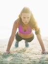 Healthy young woman doing push ups on beach Royalty Free Stock Photo